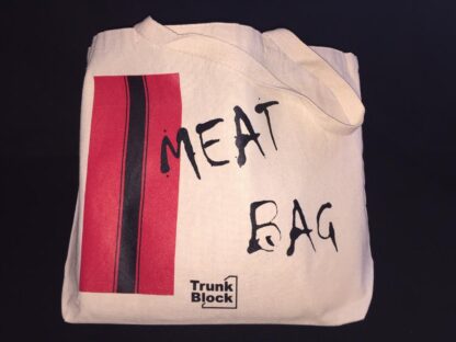 Canvas bag with red and black racing stripes on one side and the words Meat Bag in black splatter font.